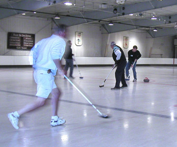 Curlers moving with the shot